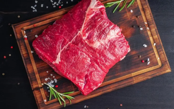 raw-meat-beef-steak-with-seasoning-on-chopping-board-on-dark-background-with-rosemary--1024x1024